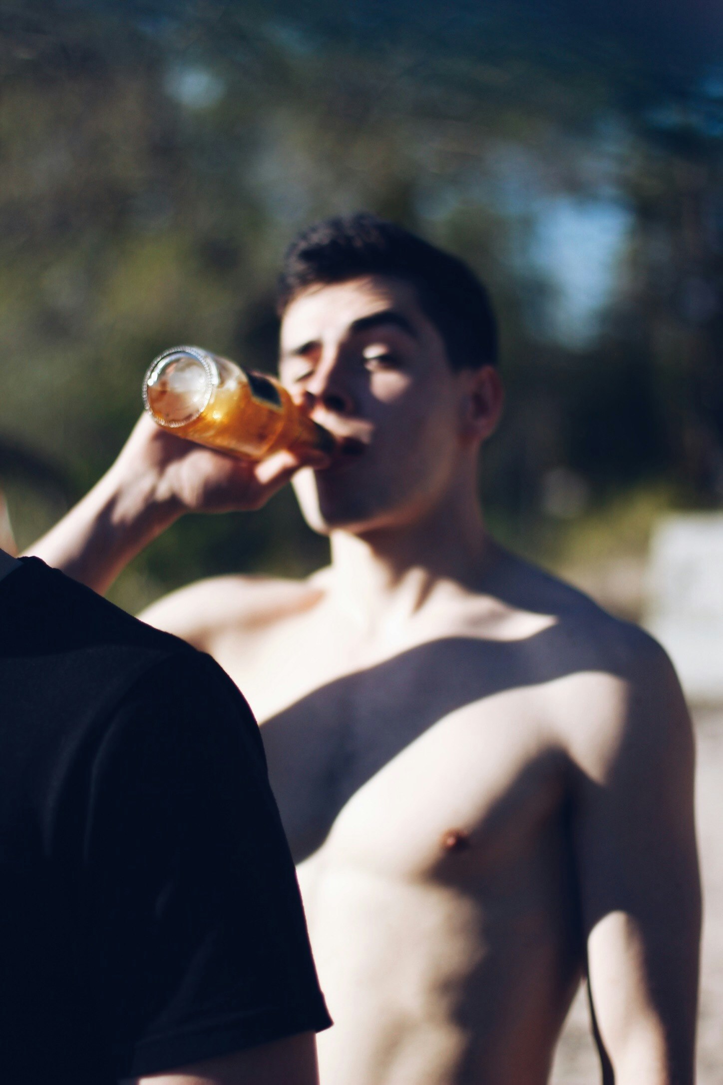 man drinking beverage in bottle